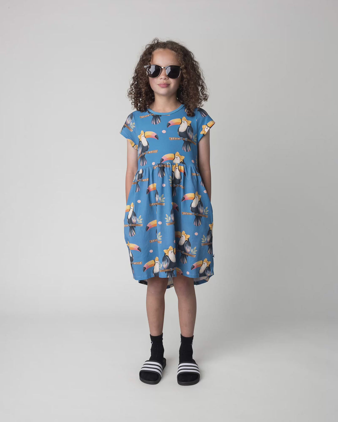 Kid wearing the Hello Toucan Dress in aqua, full circle video
