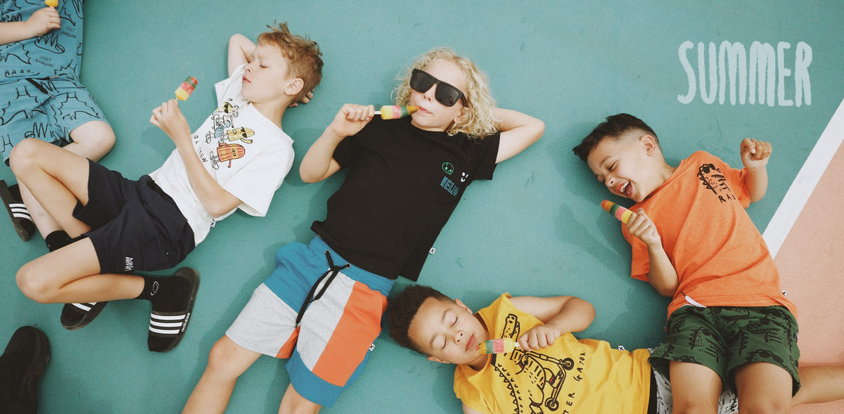 Kids lying on a court with ice blocks, wearing Minti summer tees and shorts